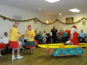 Santa arrives on a surf canoe - suitably attired!
